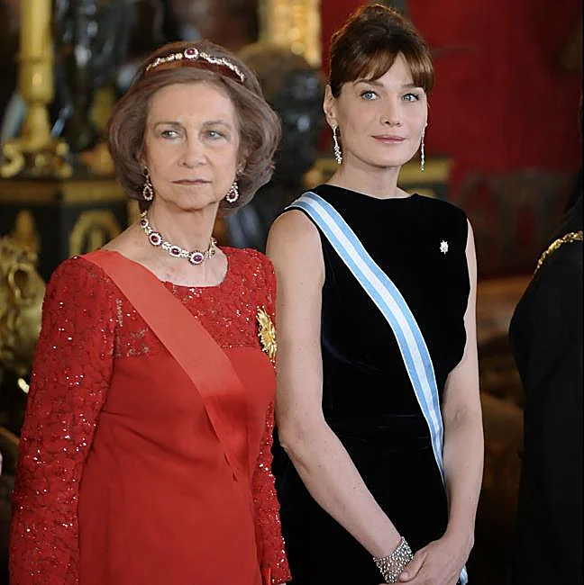 Doña Sofía dans une robe rouge caractéristique de Valentino, avec Carla Bruni.